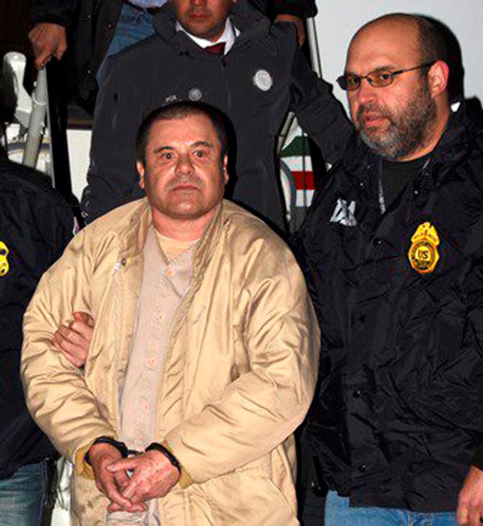 Joaquin "El Chapo" Guzman in handcuffs and being led by law enforcement officers