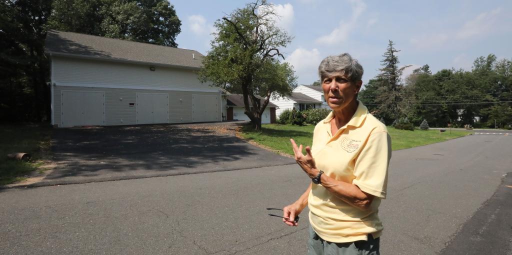 Hilda Kogut, Chair of CUPON of Chestnut Ridge, standing in a driveway by a garage building purportedly used as a shul on Spring Hill Terrace, Chestnut Ridge, August 7, 2018.