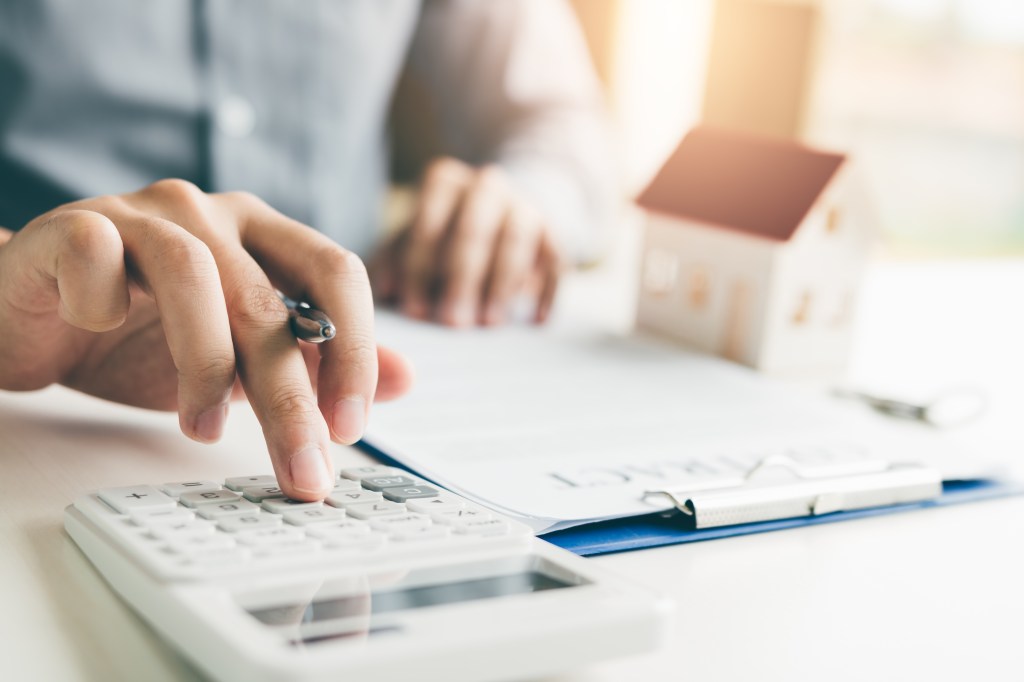 Home agent using a calculator to calculate monthly loan payments for a customer