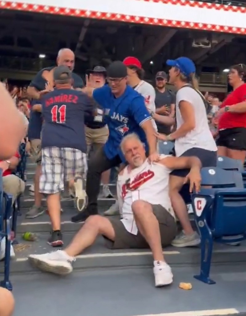 A man sitting on the ground with another man on his back during a Cleveland Guardians fight