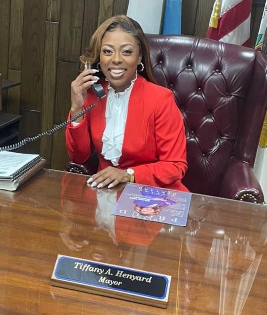 Illinois Mayor Tiffany Henyard sitting at a desk, talking on a phone, facing criminal probe allegations