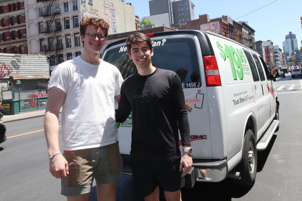 Driver and roommate are safe in front of van after finding snake while driving.