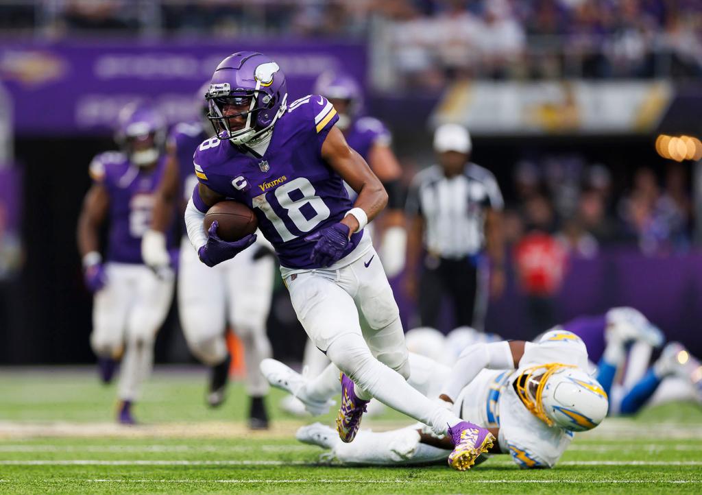 Justin Jefferson #18 of the Minnesota Vikings runs the ball after a catch on his way to score a touchdown during an NFL football game against the Los Angeles Chargers at U.S. Bank Stadium on September 24, 2023 in Minneapolis, Minnesota. 