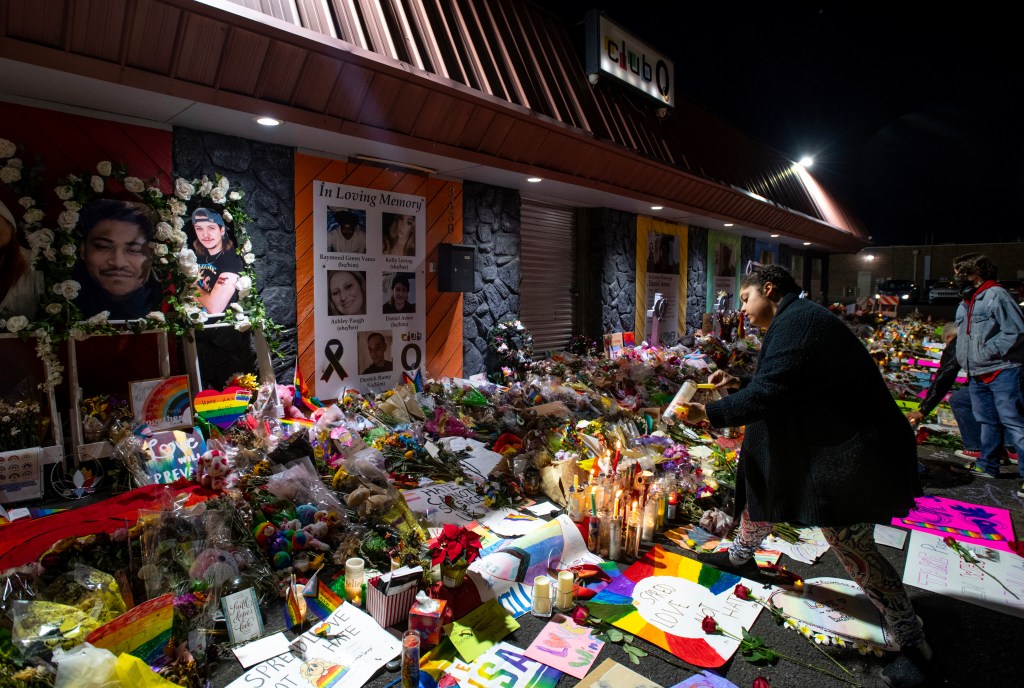 Kebrina Chirdon lighting candles at a memorial outside of Club Q in Colorado Springs, in remembrance of the five people murdered in 2022.