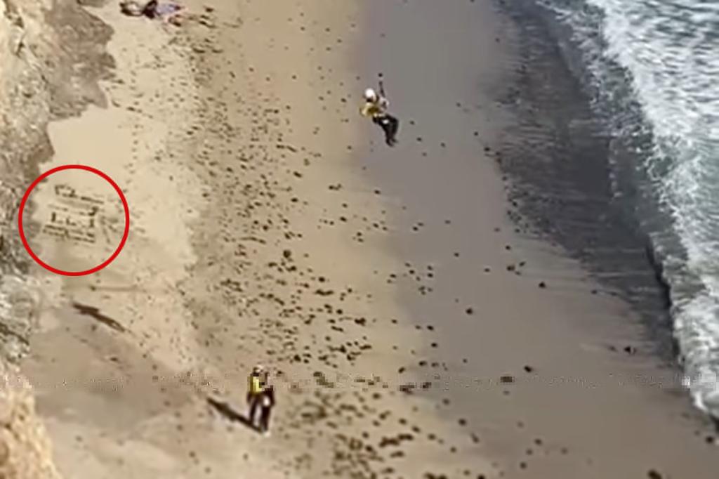 Kite surfer being rescued off a beach, having spelled out 'HELP' with rocks, spotted by a private helicopter