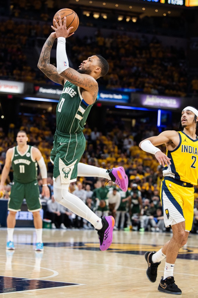 Milwaukee Bucks guard Damian Lillard (0) shoots the ball while Indiana Pacers guard Andrew Nembhard (2) defends during game three of the first round for the 2024 NBA playoffs at Gainbridge Fieldhouse on April 26, 2024. 
