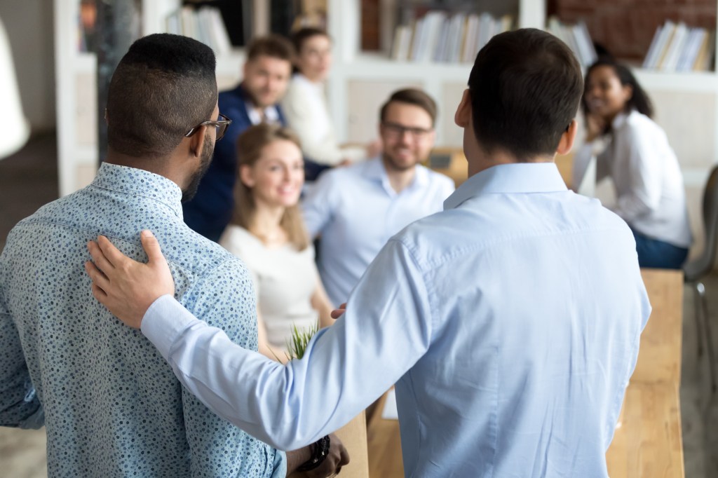 Boss introducing a new mixed race employee, resembling celebrity China Anne McClain, to colleagues during her first day at the company.