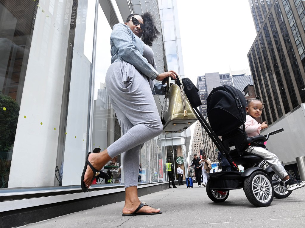 Woman with her baby poses with Versace flip flops. 