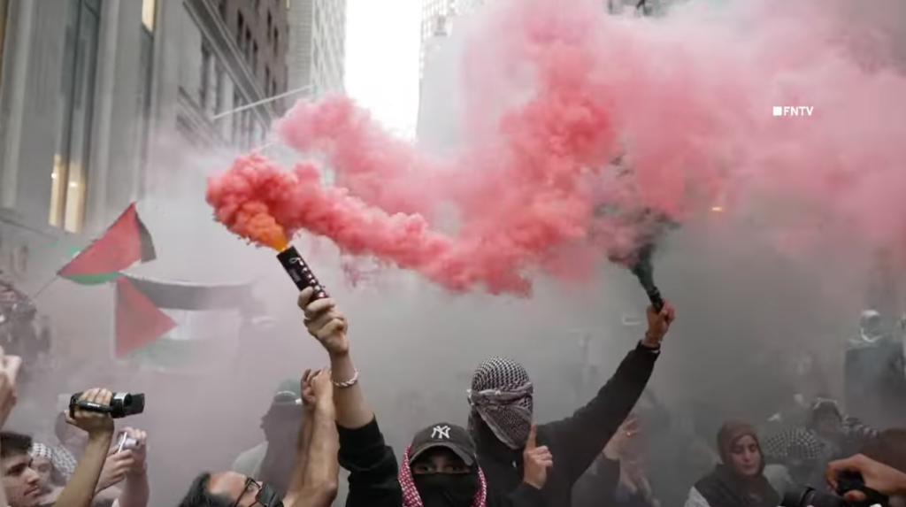 Protesters hold flares outside an Oct. 7 memorial.