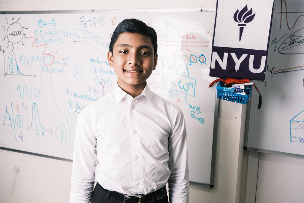 12-year-old prodigy Suborno Issac Bari standing in front of a whiteboard, preparing for his Physics and Math major at NYU