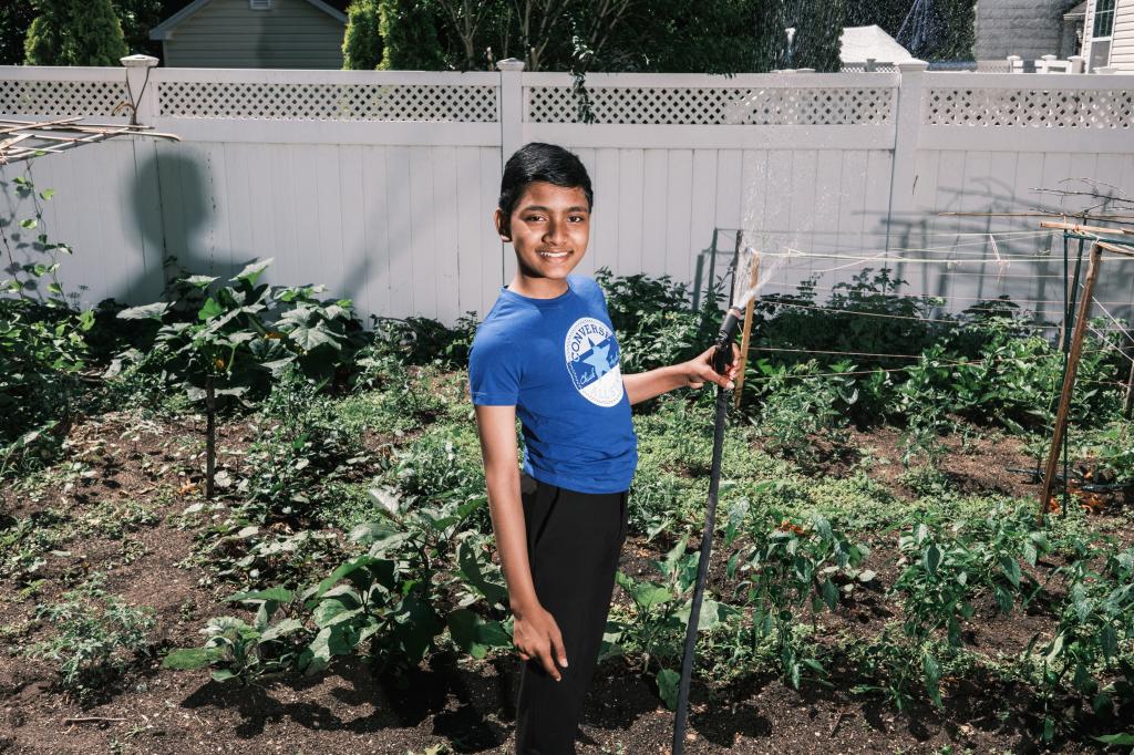 12-year-old prodigy, Suborno Issac Bari, holding a sprinkler in a garden, headed to NYU for Physics and Math