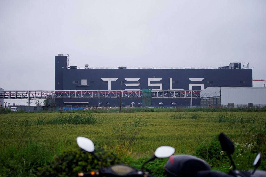 A Tesla sign in white on a grey building.