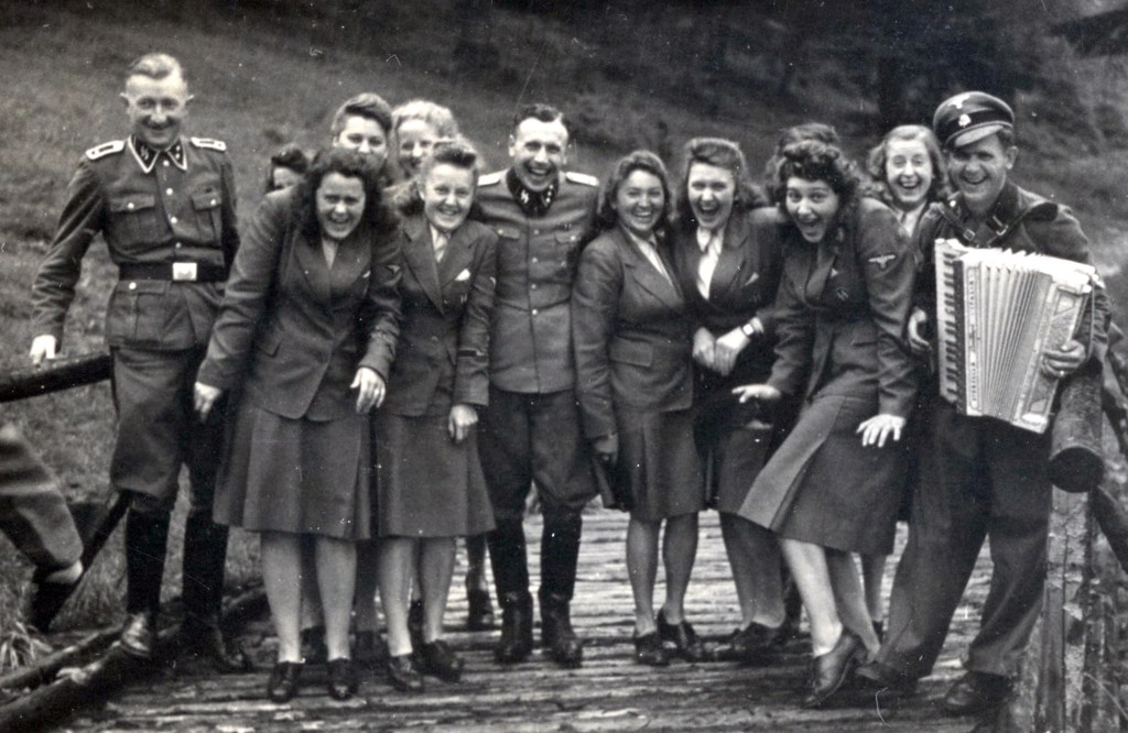 Uniformed women pose for a picture with a male Nazi at Solahütte, a little known SS resort some 30 km south of Auschwitz on the Sola River.  A chilling photo album shows Nazis at Auschwitz enjoying blueberries and sunbathing in deckchairs. The candid moments were captured on camera as 1.1 million people were murdered at the death camp. The album was found by an unnamed American counterintelligence officer who was billeted in Frankfurt after Germany's surrender in 1945. The photos are now the subject of a play that opened last month off-broadway, the 2024 Pulitzer Prize for Drama finalist Here There Are Blueberries. The play dramatises the work of the curators who examined the mysterious album featuring the Nazi-era photographs that arrived at the desk of a U.S. Holocaust Memorial Museum  (USHMM) archivist in 2007. The album consists of 116 photographs taken during the last six months of Auschwitz, between June 1944 and January 1945. The album shows Auschwitz during its most lethal period, coinciding with the murder of 400,000 Hungarian Jews.
