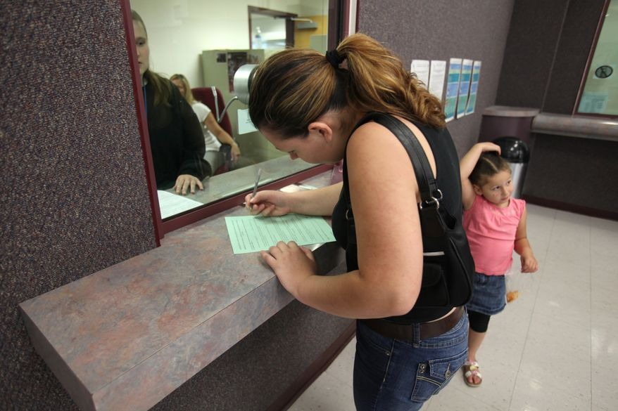 A woman fills out a form at the Sacramento County welfare office in California.