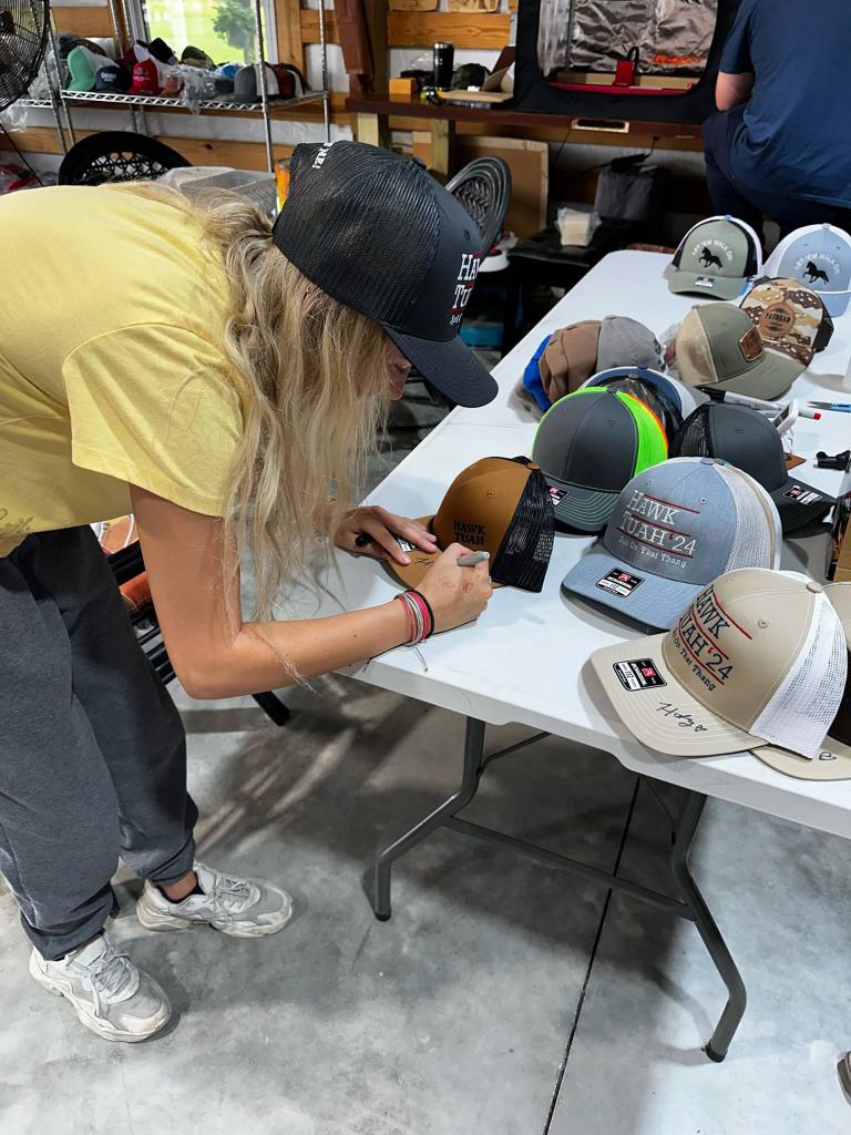 Hailey Welch signing one of her hats.