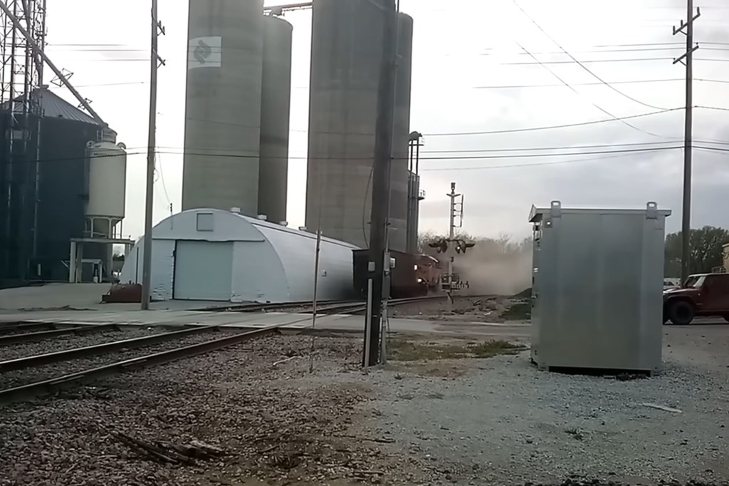 A train can be seen stirring up plumes of dirt as it starts to come off the tracks