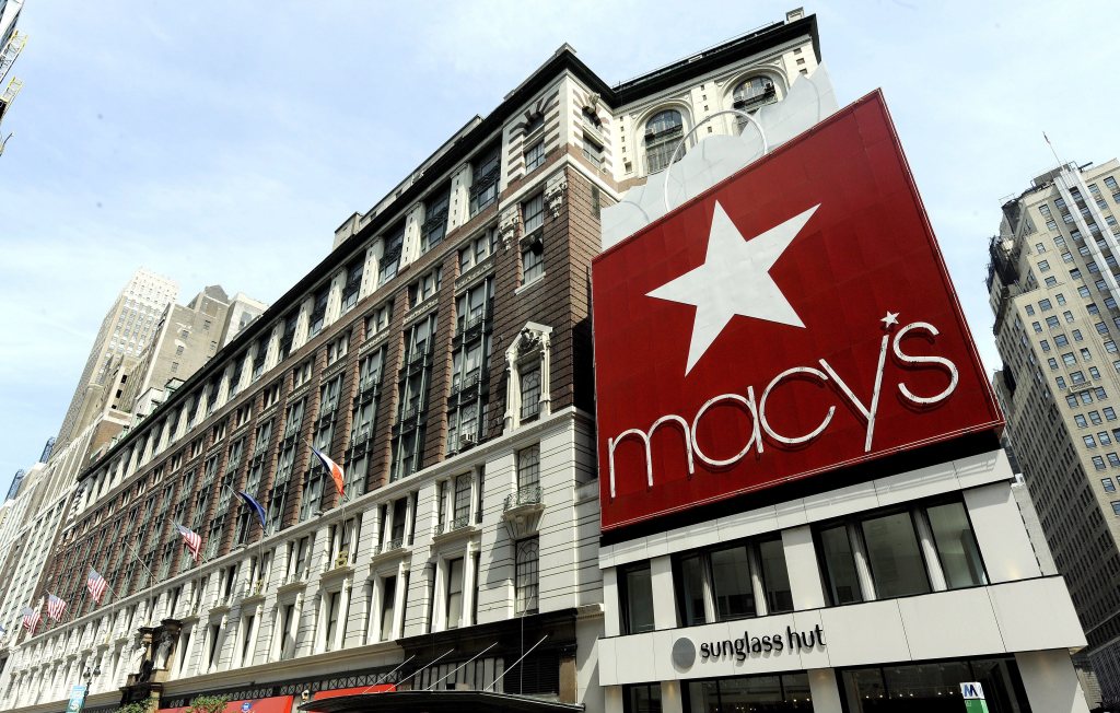 Exterior view of Macy's flagship store in New York with a large red sign and white star, reflecting a period of decline in company profits