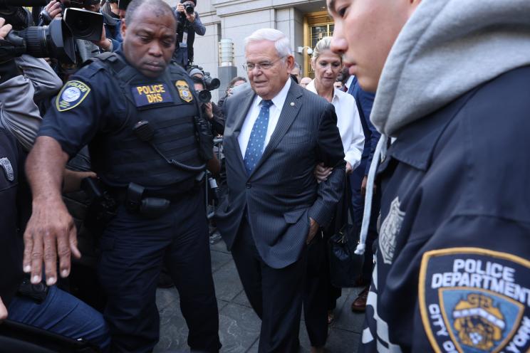 Robert Menendez and his wife being escorted by NYPD.