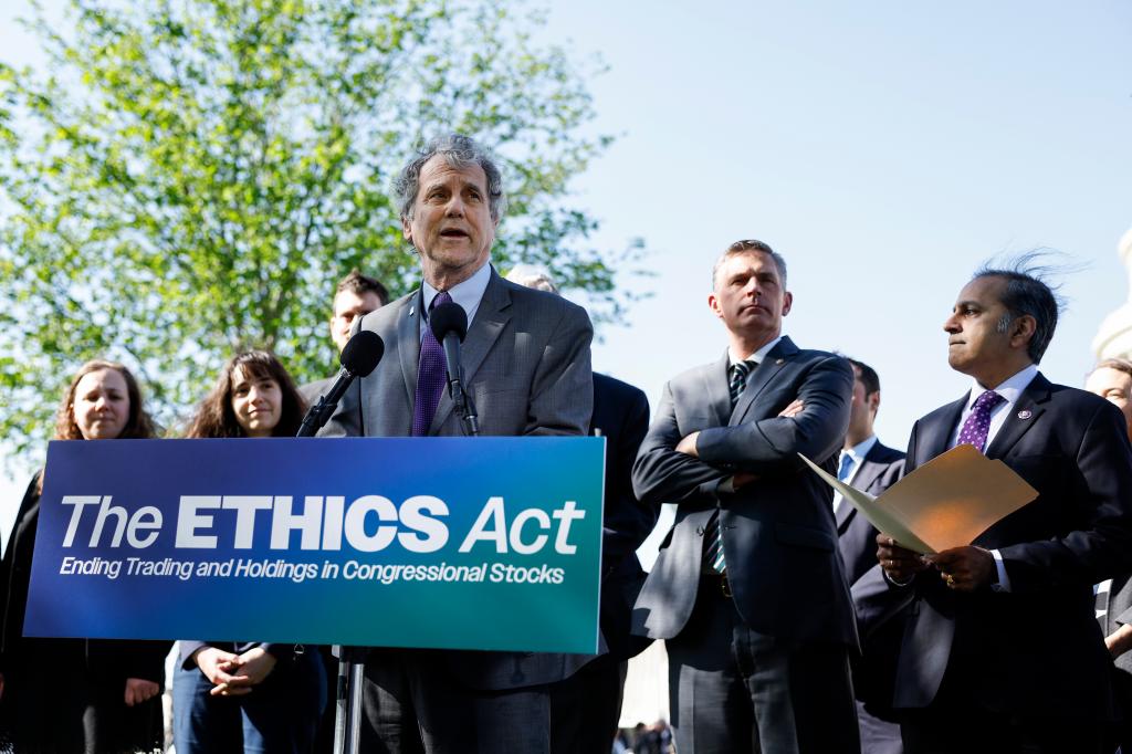 Senators stand behind a "The Ethics Act" sign at a press conference.