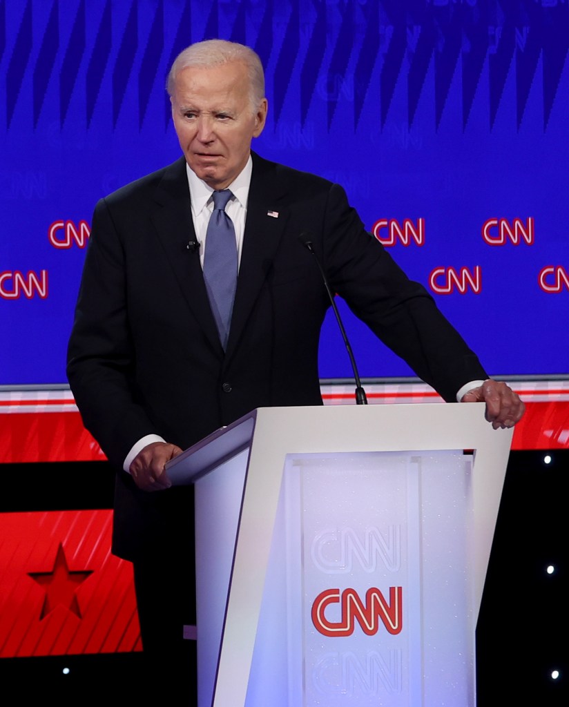 A man stands at a podium with the words "CNN" on a screen behind him. The podium says "CNN."