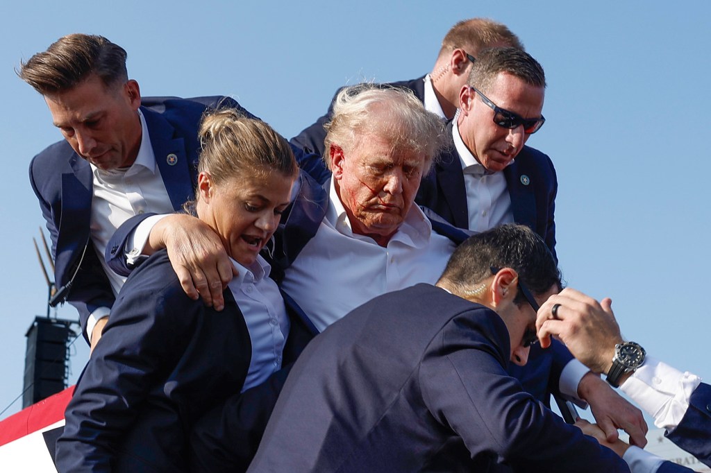 Trump is escorted off stage by Secret Service after the Pennsylvania rally assassination attempt.