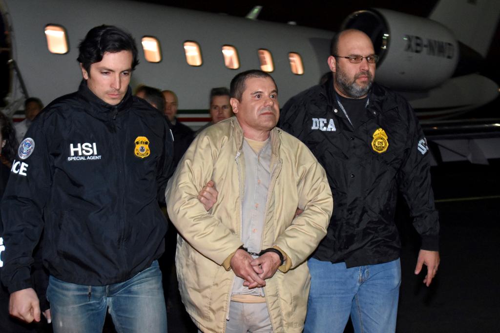 Authorities escort Joaquin "El Chapo" Guzman from a plane to a waiting caravan of SUVs at Long Island MacArthur Airport, in Ronkonkoma, N.Y.