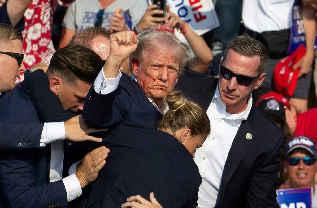 Trump raising his fist to the crowd after getting shot.