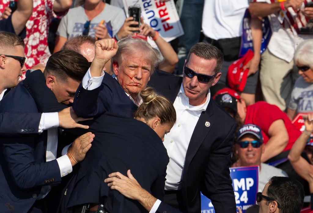 Donald Trump is escorted by Secret Service off the campaign stage after the assassination attempt.