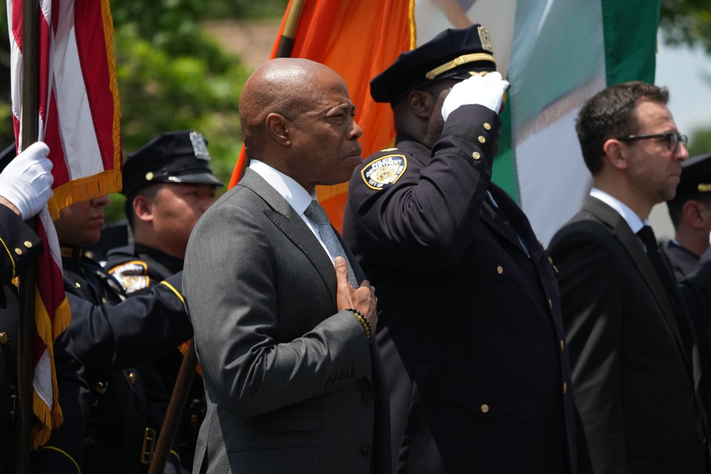 The mayor is seen holding his hand over his heart at funeral.