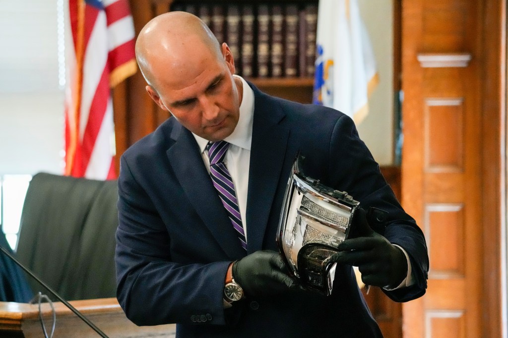 Proctor showing the jury a broken tail light at the trial.