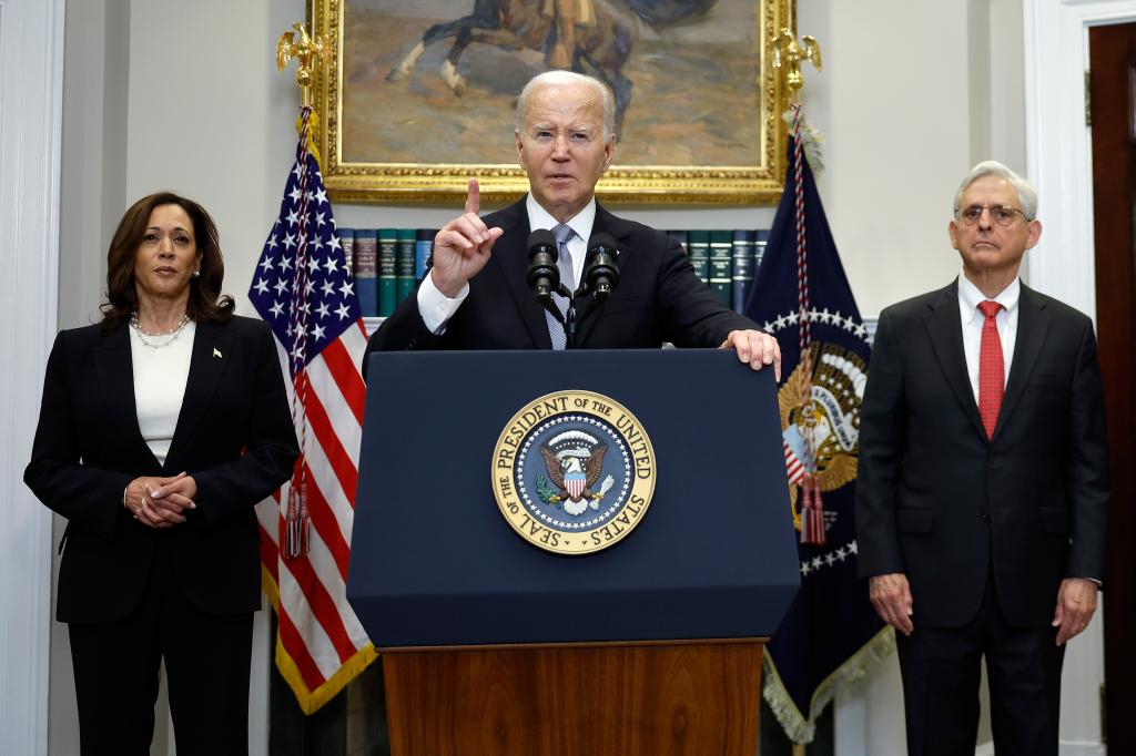 U.S. President Joe Biden, Vice President Kamala Harris, and Attorney General Merrick Garland standing together, with Biden addressing the assassination attempt on former President Donald Trump from a podium.