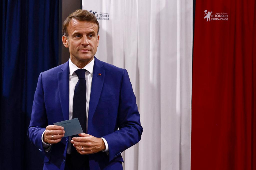 French President Emmanuel Macron leaves the voting booth before voting in the early French parliamentary election.