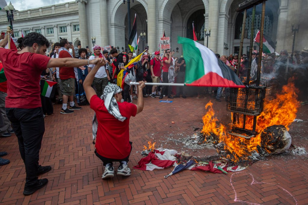 Anti-Israel demonstrators burn a US flag and a puppet of Israeli Prime Minister Benjamin Netanyahu at Union Station.