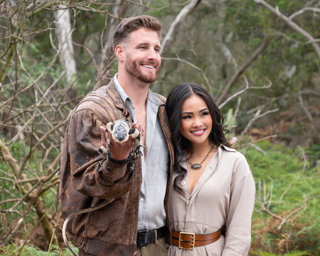 Sam M. holding a reptile and posing with Jenn Tran in Australia.