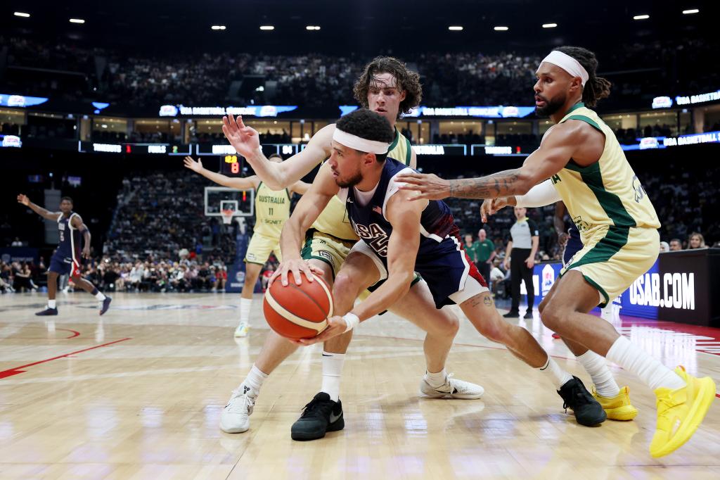 Devin Booker competing for a basketball with Josh Giddey and Patty Mills during an exhibition game between the United States and Australia