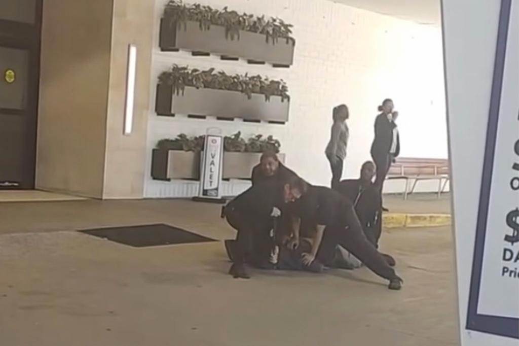 Witness videos show the guards pinning Mitchell down outside the hotel. 