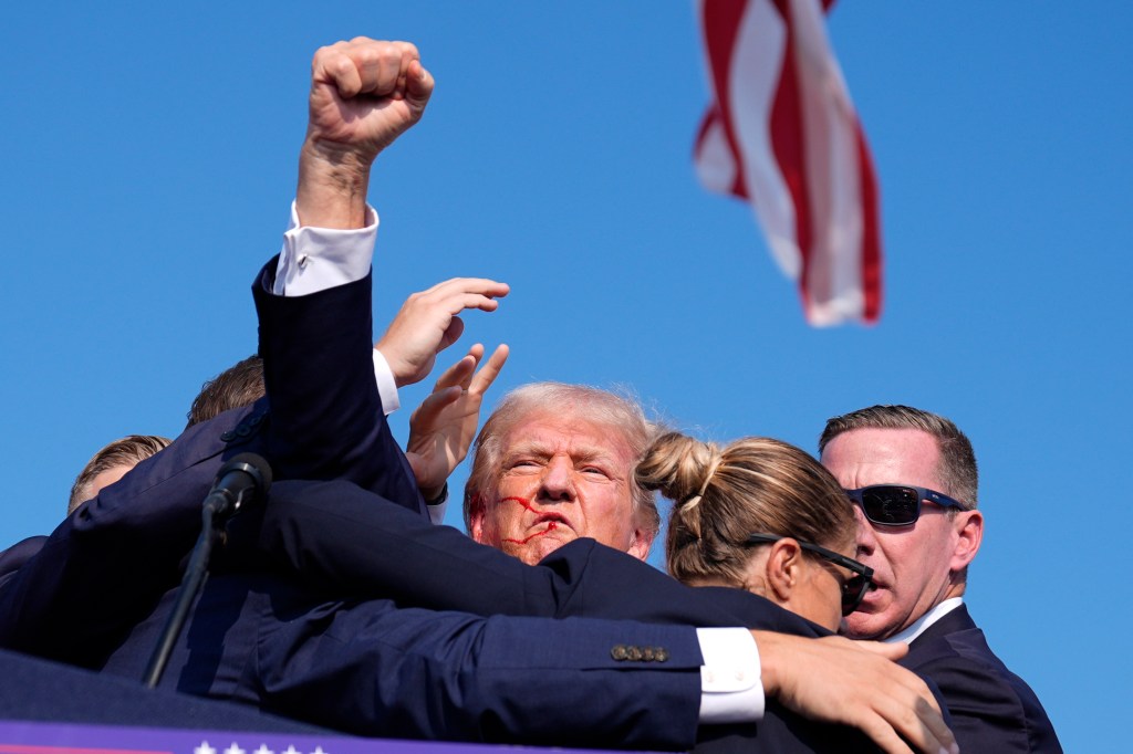 former President Donald Trump is surrounded by U.S. Secret Service agents at a campaign rally, Saturday, July 13, 2024, in Butler, Pa.