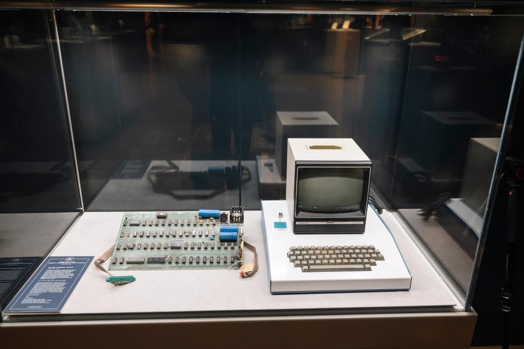 Apple 1 computer and keyboard displayed in a glass case