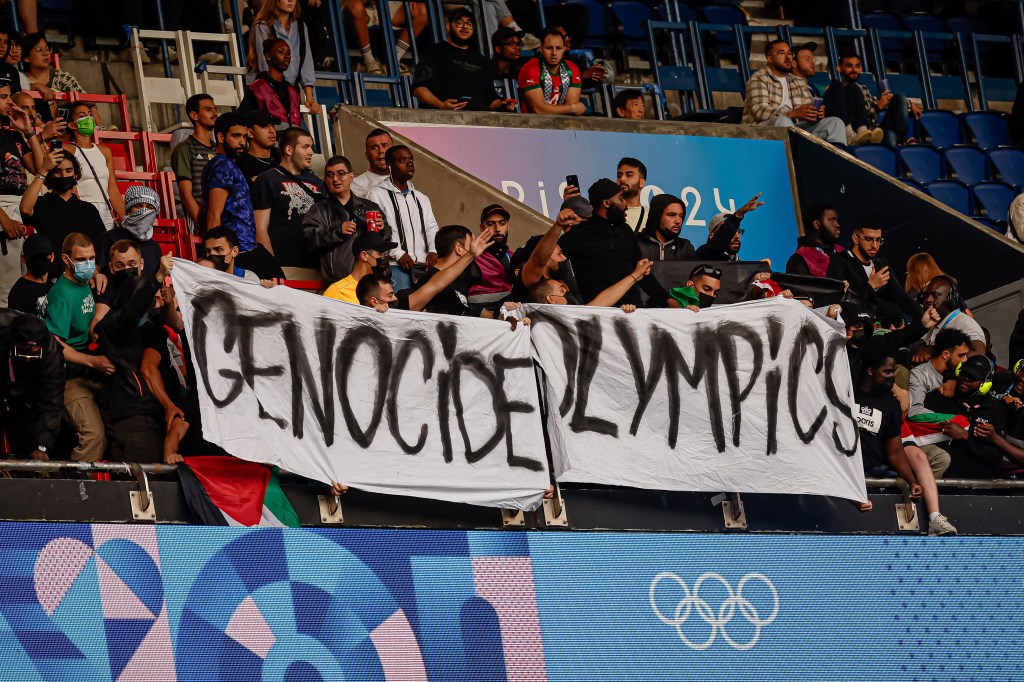 Multiple people were also seen brandishing a large sign that read “Genocide Olympics.”