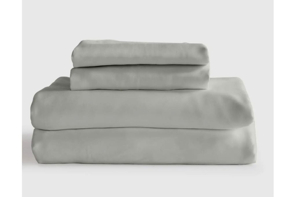 A stack of grey bed sheets and pillow cases.