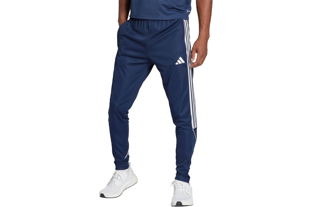 A man wearing blue Adidas track pants.