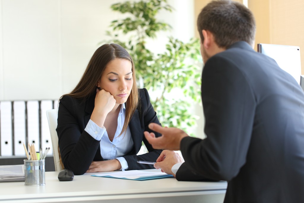 A salesman trying to convince an uninterested woman in her office