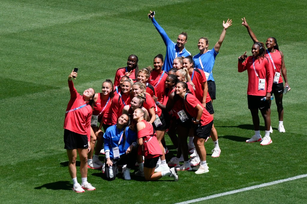 Canada's players pose for photos on the pitch at Geoffroy-Guichard Stadium ahead of the 2024 Summer Olympics ion Tuesday, July 23.