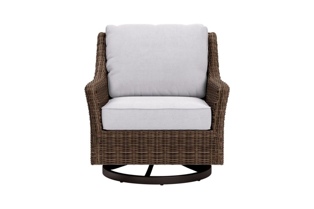 A wicker chair with a white cushion