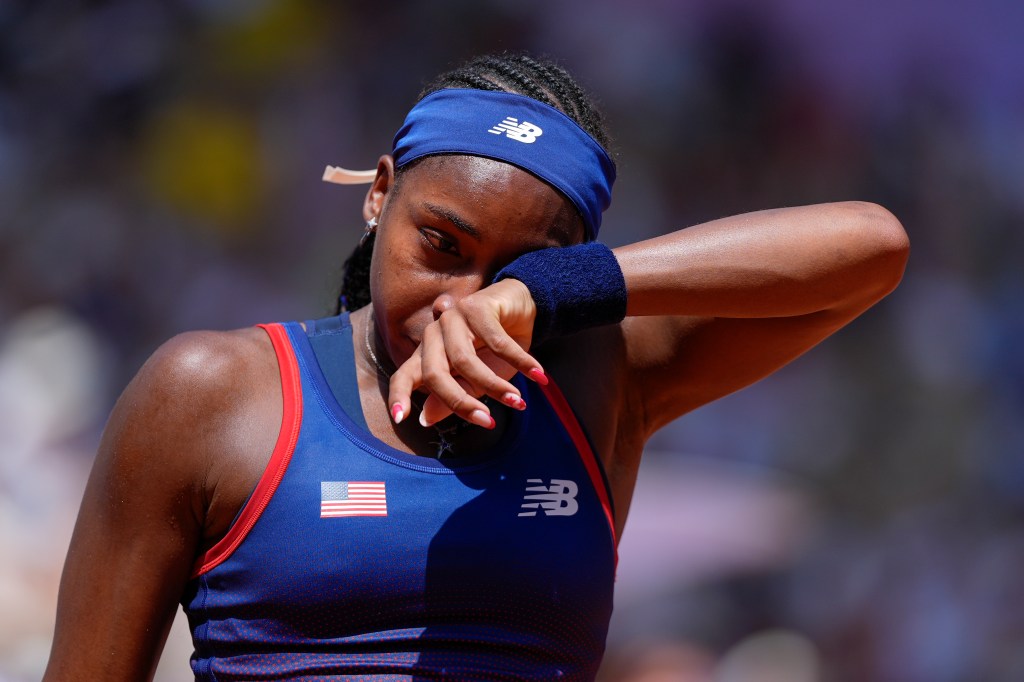 Coco Gauff wipes away tears after arguing with an umpire during her Olympics loss on July 30, 2024.