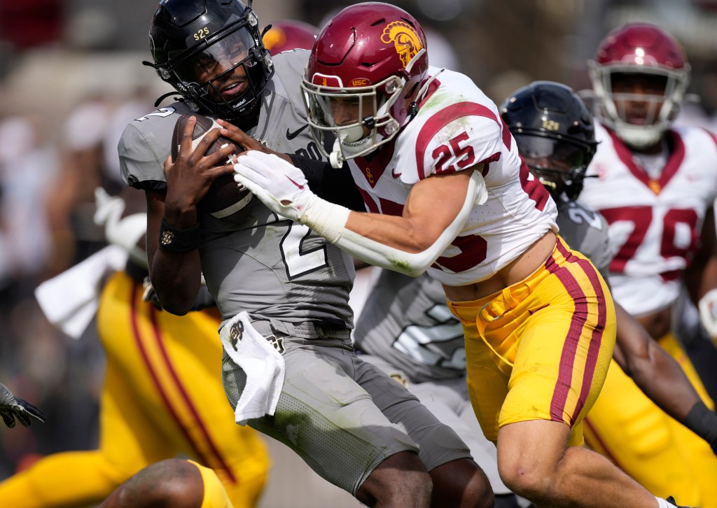 Colorado quarterback Shedeur Sanders, left, is stopped by Southern California linebacker Tackett Curtis (25) this season.