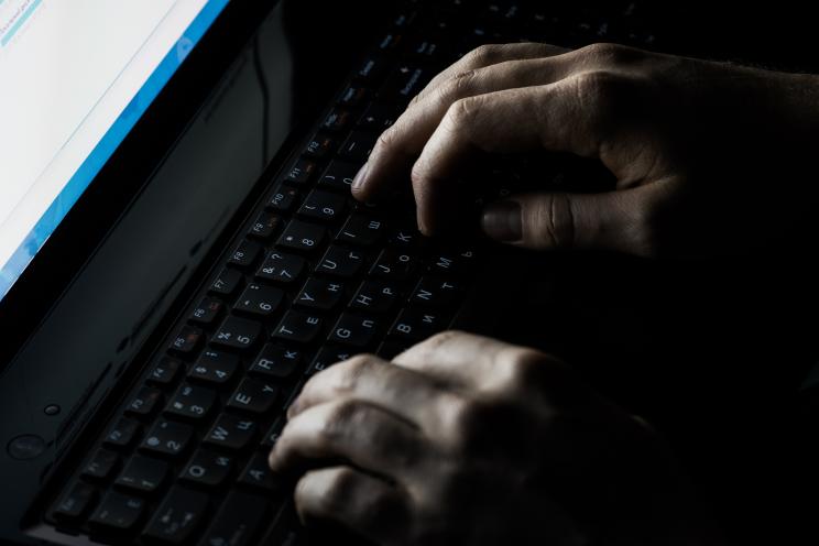 Hands typing on a keyboard symbolizing cyber warfare in relation to the global Microsoft computer outage