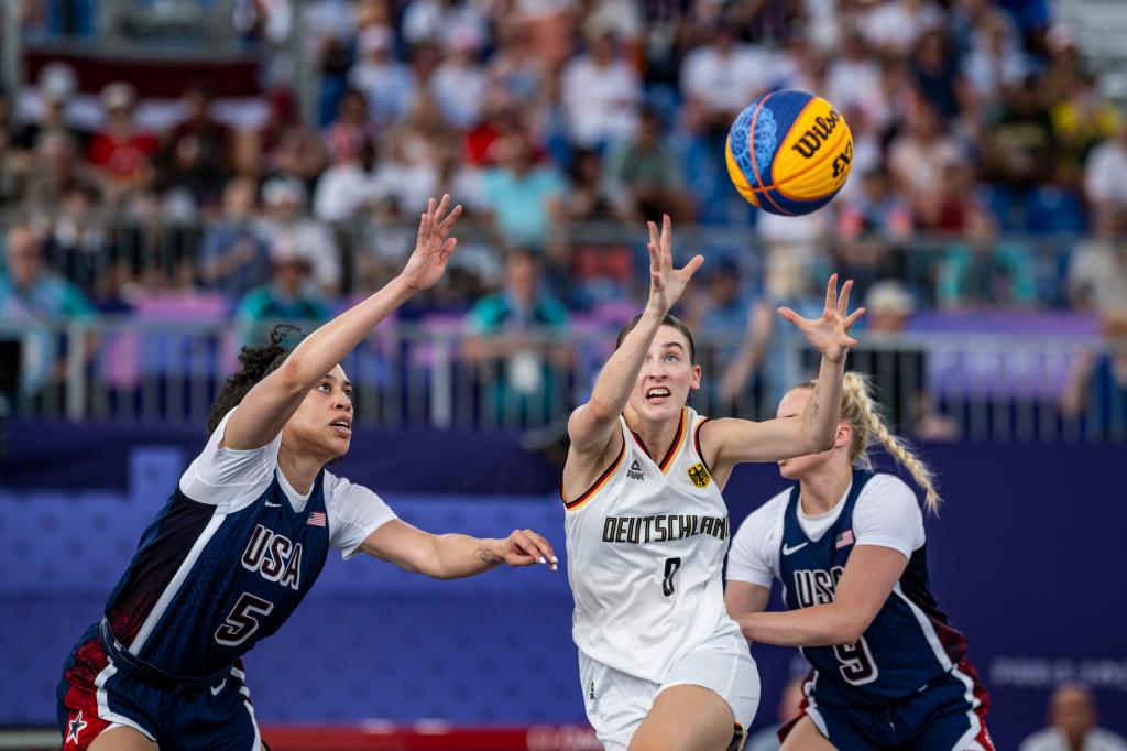 Dearica Hamby of Team USA, Elisa Mevius of Team Germany and Hailey van Lith of Team USA in action during the Women's Pool Round match between Germany and United States of America on day four of the Olympic Games Paris 2024 at the Esplanade Des Invalides on July 30, 2024 in Paris, France.