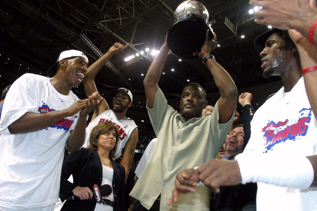 (L-R) Chauncey Billups #1, Rasheed Wallace #30, President of Basketball Operations Joe Dumars (holding trophy) and Ben Wallace #3 of the Detroit Pistons celebrate their win over the Indiana Pacers in Game six of the Eastern Conference Finals during the 2004 NBA Playoffs at The Palace of Auburn Hills on June 1, 2004 in Auburn Hills, Michigan.  The Pistons defeated the Pacers 69-65 and won the 2004 Eastern Conference Championship.  