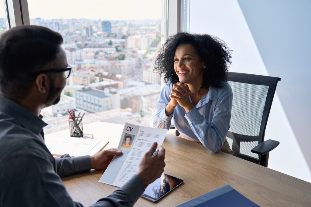 Indian HR manager conducting a job interview with an African American female applicant in a contemporary office